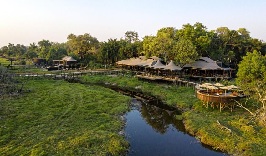 Aerial view of Xigera Safari Lodge nestled among lush trees and waterways in the heart of Botswana’s Okavango Delta.